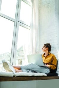 Jeune fille assise regardant par la fenêtre