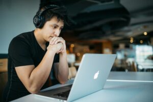 étudiant devant un ordinateur entrain de réfléchir